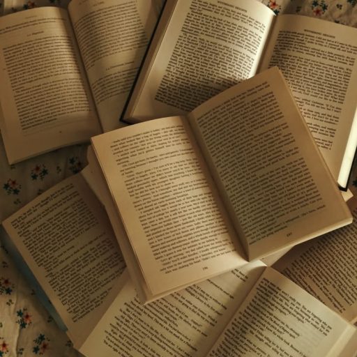 Books open on a table, displaying the carefully crafted words inside.